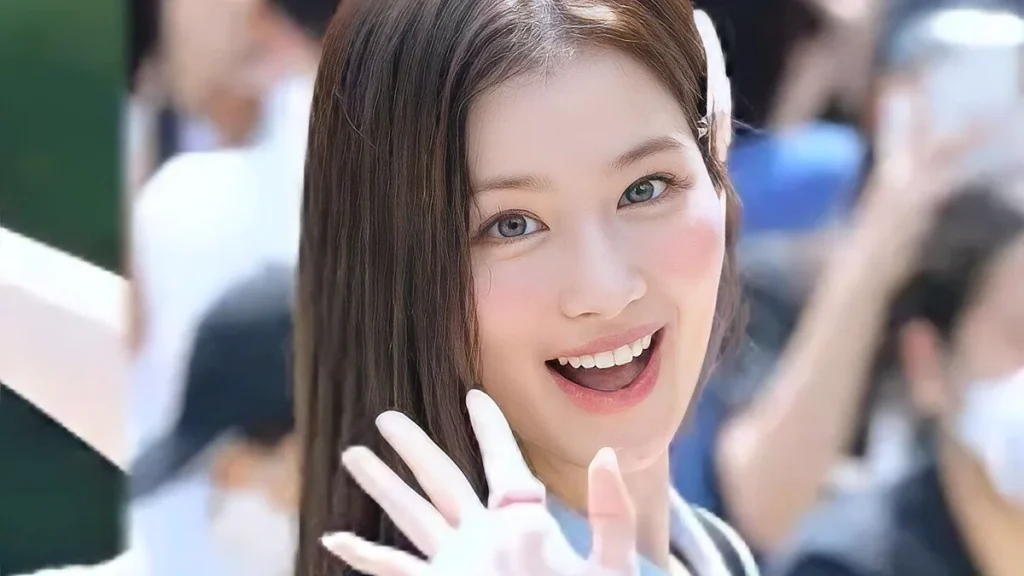 Sana of TWICE smiling and waving at a 2022 fan meeting
