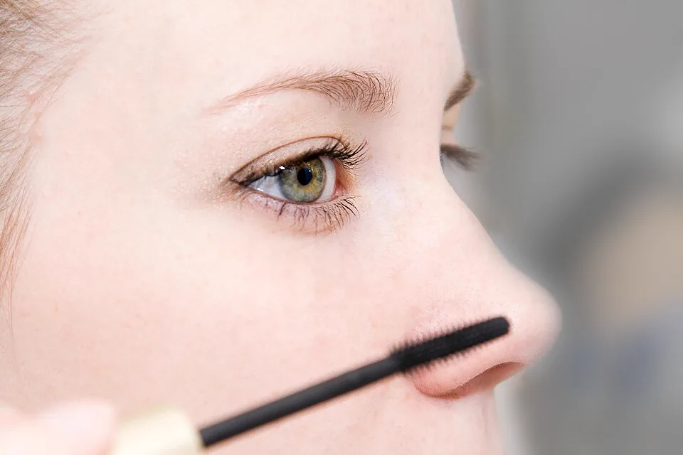 Mascara wand held near the lashes during application