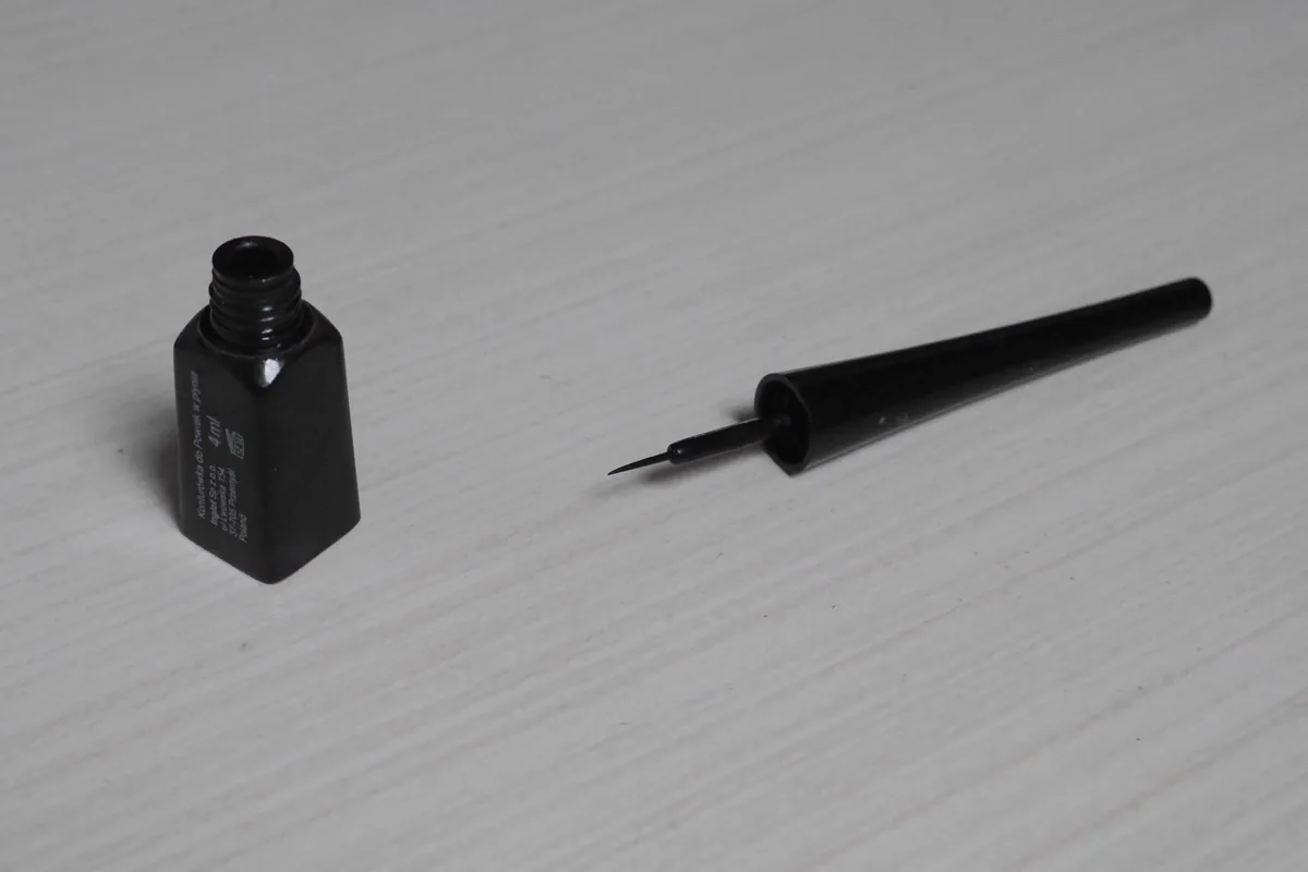 A liquid eyeliner bottle with its fine brush applicator removed