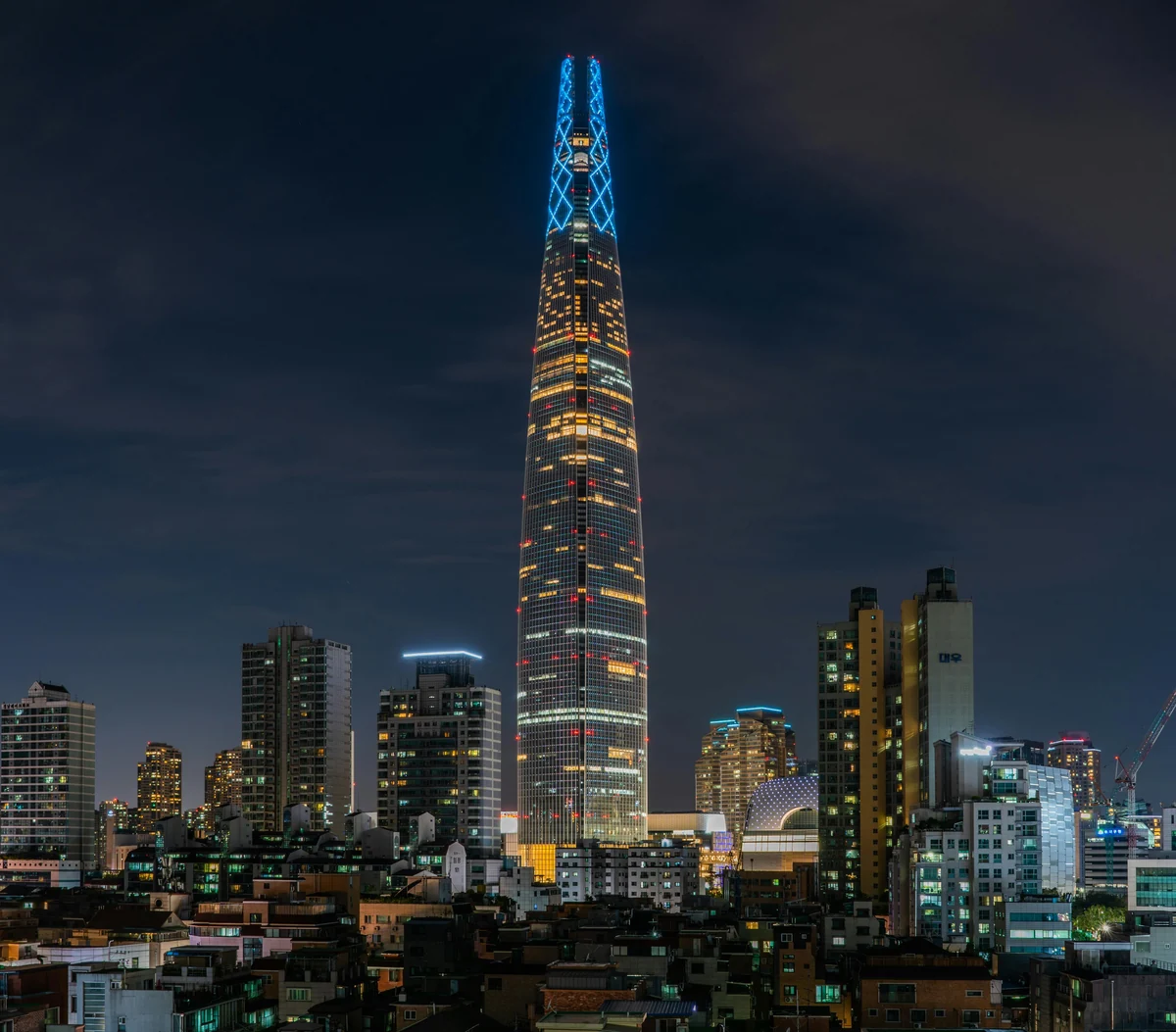 Lotte World Tower illuminated at night above the Jamsil skyline in Seoul