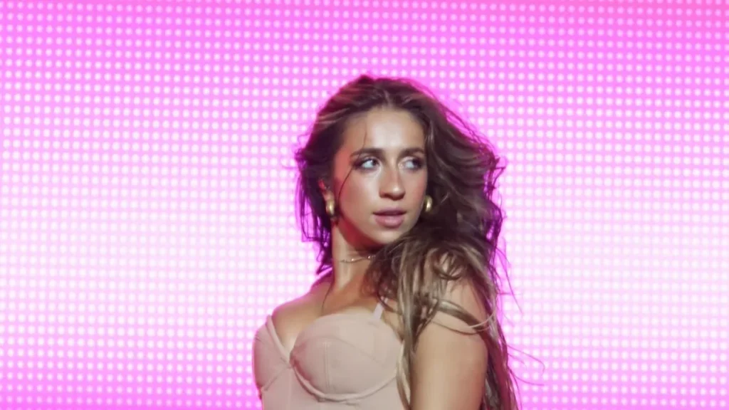 Tate McRae performing onstage in Manila against a pink backdrop